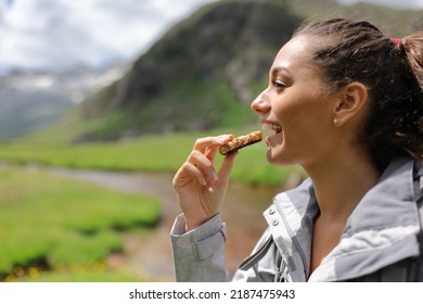Profile of a hiker eating a cereal bar in the mountain - Shutterstock ID 2187475943
