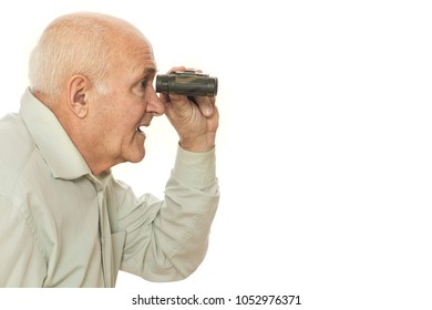 Profile Horizontal Shot Of A Seniro Man Looking At The Copyspace Through Binoculars. Old Man Using Binoculars At Studio Looking Surprised Isolated On White.