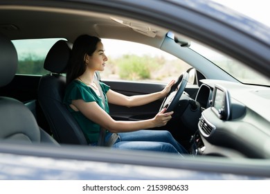 Profile Of A Latin Woman Driving Her Car On The Road. Young Woman Driving To Meet A Friend