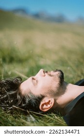Profile of a man lying on green grass - Shutterstock ID 2262134471