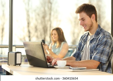 Profile Of A Man Sitting And Working With A Laptop In A Coffee Shop At Sunset With A Warmth Background