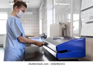 Profile Of A Nurse Using A Seal Machine In An Hospital Room