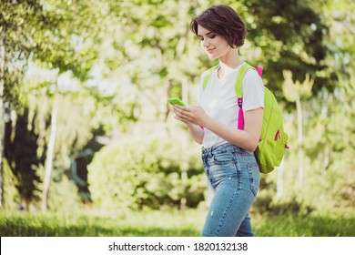 Profile Photo Of Attractive Freelancer Lady Hold Telephone Go College Classes Forest Path Use Navigation System Short Way School Backpack On Shoulders Wear T-shirt Jeans Green Park Outdoors