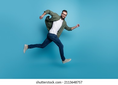 Profile photo of cheerful nice guy jump sporty run wear specs green shirt jeans isolated blue color background - Powered by Shutterstock