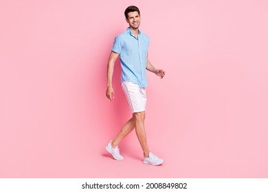Profile photo of handsome guy walk shiny white smile wear blue shirt shorts shoes isolated on pink color background