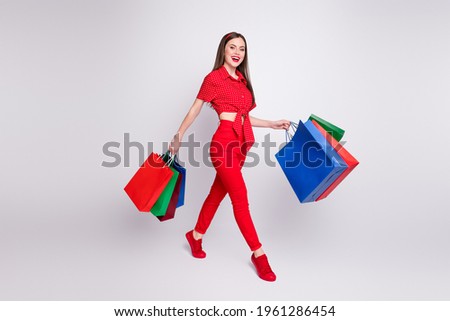 Profile photo of lovely customer lady hold many bags walk wear red dotted blouse pants shoes isolated grey color background