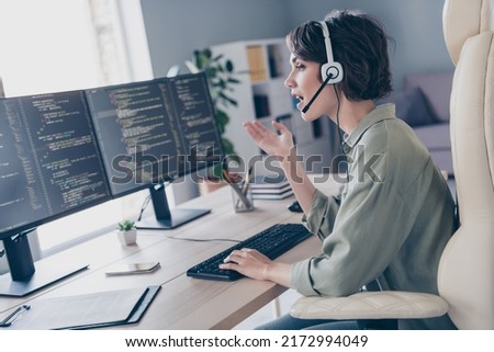 Profile photo of skilled pc expert sitting chair speak communicate clients headphones look screen workplace indoors