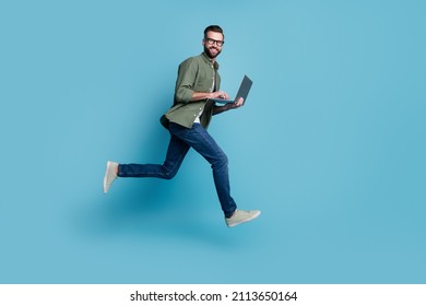 Foto de perfil del deportista tipo activo saltar sostén de netbook correr ropa de trabajo specto camisa verde aislado color azul fondo
