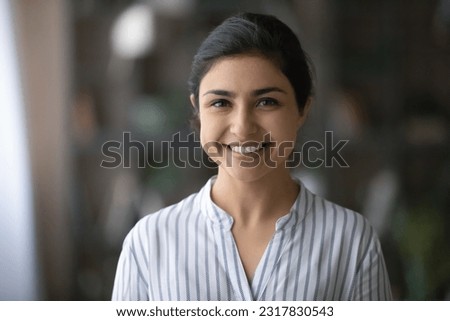 Profile picture of cheerful young female businesswoman student posing indoors. Headshot portrait of friendly casual indian lady office employee consultant look at camera able to help assist customer ストックフォト © 