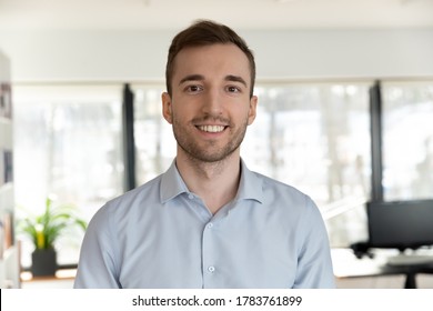 Profile picture of happy young Caucasian male employee worker look at camera posing in office workplace, headshot portrait of smiling businessman boss show confidence and success, leadership concept