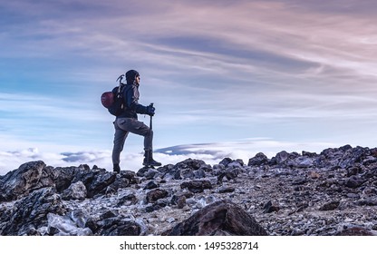 Profile picture of mountaineer prepared with his gear on top of the mountain contemplating the beautiful colors of the sky at sunrise, taken in the snowy of Tolima Colombia