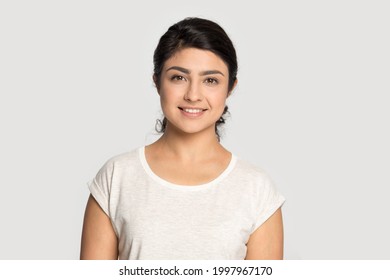 Profile picture of smiling millennial Indian woman isolated on gray studio wall background feeling confident. Headshot portrait of happy young mixed race female intern employee. Recruitment concept. - Powered by Shutterstock