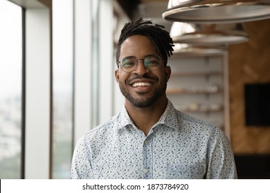 Profile picture of smiling young African American man in glasses pose in own home apartment. Close up headshot portrait of happy millennial biracial male renter or tenant in spectacles show optimism.