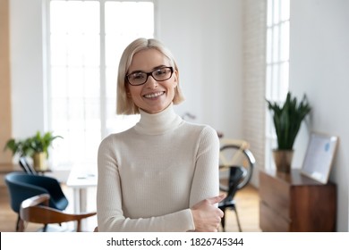Profile picture of smiling young Caucasian businesswoman in glasses show leadership confidence posing in office. Headshot portrait of happy motivated millennial female employee or worker in eyewear.