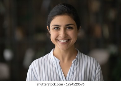 Profile picture of smiling young Indian woman client or customer feel satisfied with good quality service. Headshot portrait of happy millennial mixed race female teacher or coach. Diversity concept.