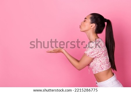 Profile portrait of adorable gorgeous malaysian lady closed eyes hands send air kiss empty space isolated on pink color background