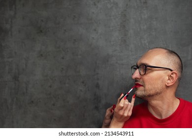 Profile Portrait Of Adult Man Applying Makeup And Red Lipstick