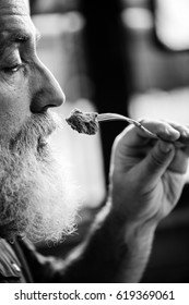 Profile Portrait Of Bearded Senior Man Eating Steak, Black And White Photo