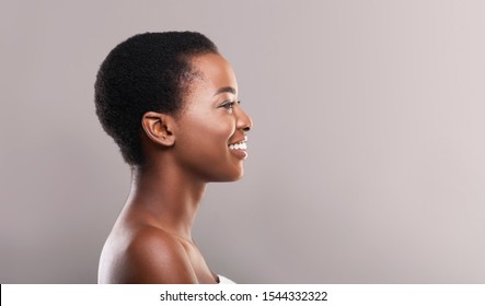 Profile portrait of beautiful african american woman with clean smooth skin and white teeth, panorama with free space