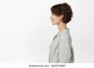 Profile Portrait Of Beautiful Smiling Woman With Short Pixie Hairstyle, Looking Left With Happy Smile, Casual Friendly Face Expression, Standing In Casual Shirt Over White Background