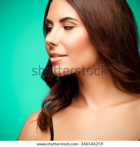 profile portrait of beautiful smiling young woman in black tank top clothing, on green background