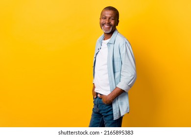 Profile portrait of cheerful nice person put hands pockets empty space ad isolated on yellow color background - Powered by Shutterstock