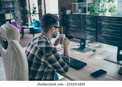 Profile portrait of clever cybersecurity expert sitting chair hold tea mug look pc screen operating database open space workplace indoors - Powered by Shutterstock