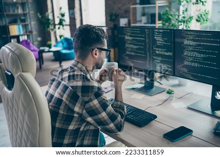 Profile portrait of clever cybersecurity expert sitting chair hold tea mug look pc screen operating database open space workplace indoors
