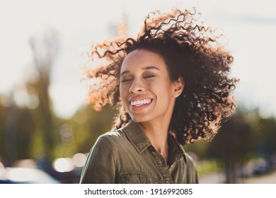 Profile portrait of curly hairstyle charming cute dark skin lady closed eyes enjoy breeze relax good mood walking outdoors