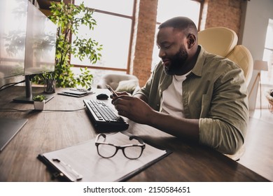 Profile portrait of happy hacker sit chair use telephone chatting texting workstation indoors - Powered by Shutterstock