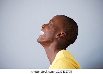 Profile Portrait Of Happy Man Laughing And Looking Up By Gray Background 