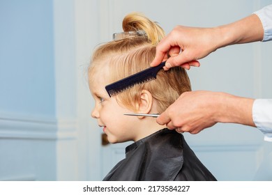 Profile Portrait Of A Little Blond Boy Smiling As Hairdresser Make Haircut