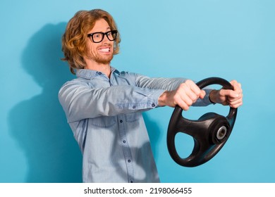 Profile Portrait Of Nervous Guy Hands Hold Steer Wheel Look Empty Space Grin Teeth Isolated On Blue Color Background