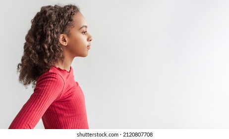 Profile Portrait Of Serious African American Preteen Girl Standing Looking Aside Posing Over Gray Studio Background, Wearing Pink Longsleeve. Panorama With Empty Space For Text