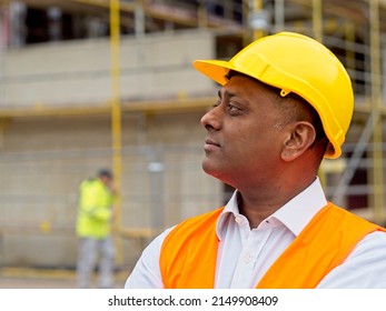 Profile Portrait Of A Serious Civil Engineer Or Factory Worker Wearing A Safety Helmet And Looking Aside