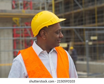 Profile Portrait Of A Smiling Civil Engineer Or Factory Worker Wearing A Safety Helmet And Looking Aside