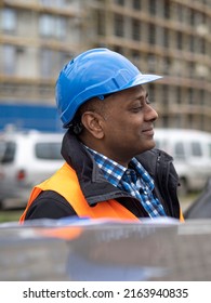 Profile Portrait Of A Smiling Indian Engineer Or Factory Worker Wearing A Safety Helmet And Looking To The Side