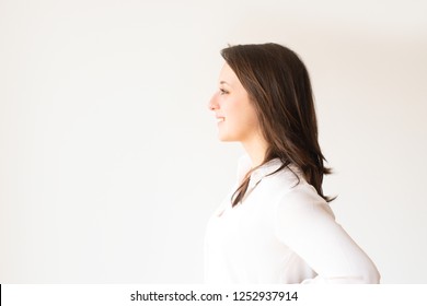 Profile portrait of smiling student in white blouse looking aside. Side view of cheerful young manager looking away. Isolated on white. Beauty concept