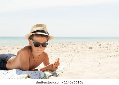 profile portrait of teenager boy in hat on beach