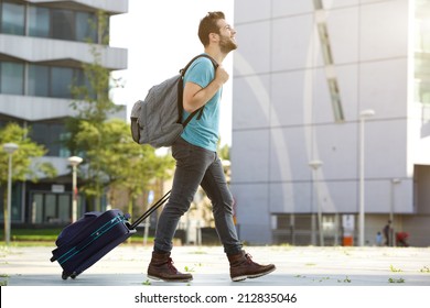 Profile Portrait Of A Young Man Walking With Suitcase And Bag