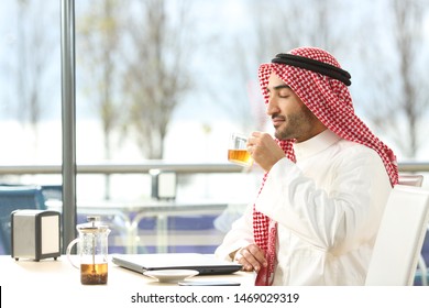 Profile Of A Relaxed Arab Man Smelling Tea In A Coffee Shop