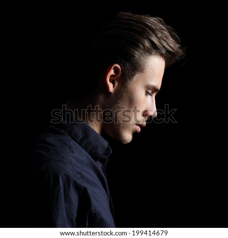Profile of a sad man face crestfallen on black isolated on a black background       