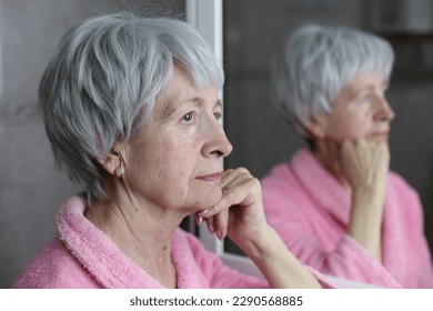 Profile of senior woman thinking with her own reflection  - Powered by Shutterstock