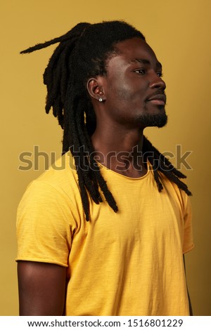 profile of serious handsome man with stylish hair looking at the distance. close up side view portrait. isolated yellow background