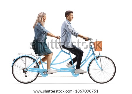 Profile shot of a casual young man and woman riding on a tandem bicycle isolated on white background