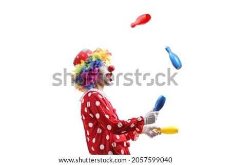 Profile shot of a clown juggling with clubs isolated on white background