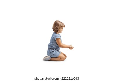 Profile shot of a little girl holding grain food in her hands and kneeling isolated on white background