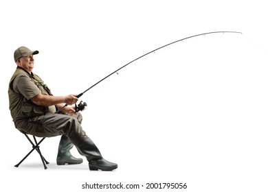 Profile shot of a mature fisherman sitting on a chair with a fishing rod isolated on white background - Powered by Shutterstock