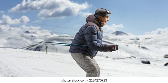 Profile Shot Of A Mature Man Skiing On A Mountain