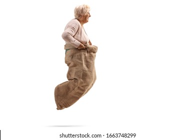 Profile Shot Of A Senior Woman Playing A Gunny Sack Race Isolated On White Background